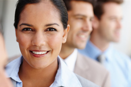 Her ambition is one of her strong points. Closeup portrait of a pretty young woman smiling at you while standing in line with her colleagues.の写真素材