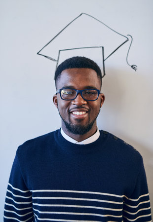I know Ill get to that milestone. a young university student standing against a whiteboard with a graduation cap drawn on it.の写真素材
