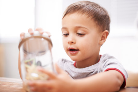 Inspecting nature. a cute young boy with a jar full of toys.の写真素材