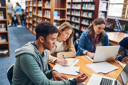 Theres only one way to succeed Work hard. a group of university student studying hard in a library.の写真素材