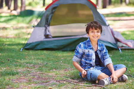 Claiming his camping spot. A boy standing in front of his campsite.の写真素材