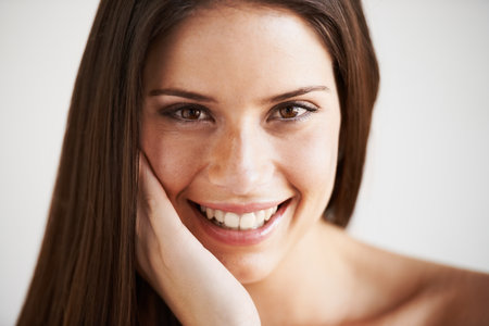 Flawless beauty. Portrait of a young woman standing against a grey background.の写真素材