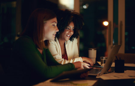 You can depend on them for their quality work and efforts. two businesswomen working together in an office at night.の写真素材