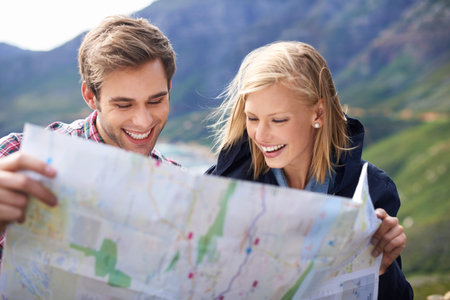 Let the map be our playground. A shot of a young couple looking at a map on their road trip.