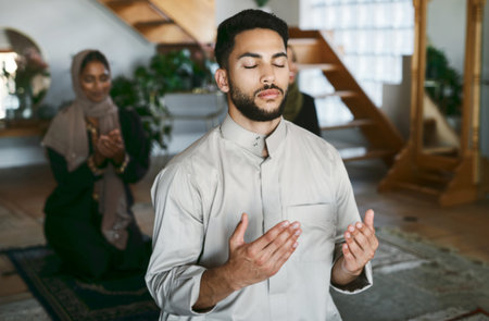 Be peaceful. a young muslim couple praying in the lounge at home.