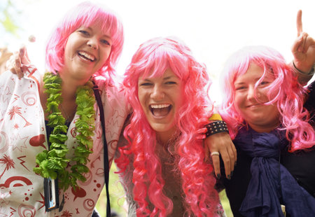 The pink brigade has arrived. Three friends having fun at a festival.の写真素材
