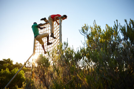 Going at it with everything theyve got. two men going over an obstacle at bootcamp.の写真素材