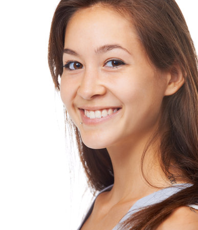 Bright smile. Closeup studio portrait of a beautiful young woman isolated on white.の写真素材