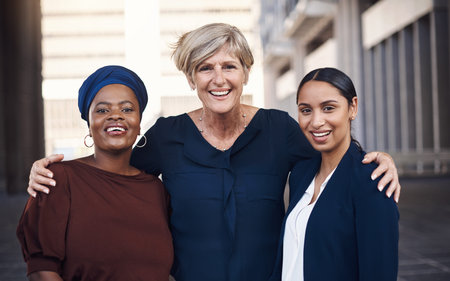 It takes strength to support each others success. Portrait of a group of businesswomen standing together against a city background.の写真素材