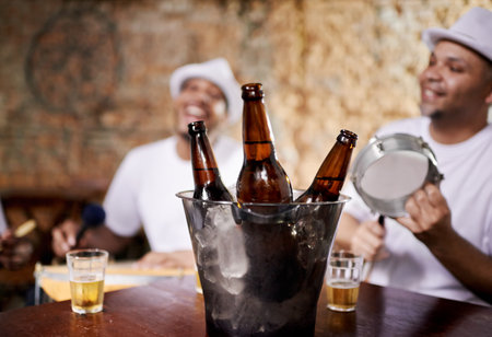 Feeling the rhythm in the drums. beer bottles with two drummers in the background.の写真素材