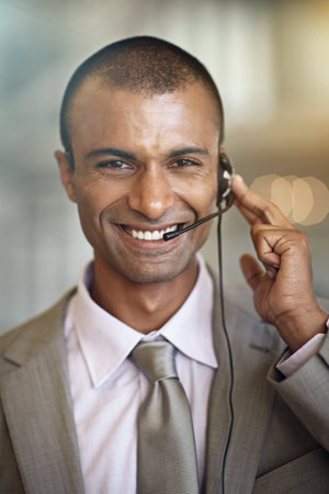 Call center, man portrait and consultant in virtual communication, business support and web helping. Smile on face of IT agent, advisor or indian person in telecom, customer service and client chatの写真素材