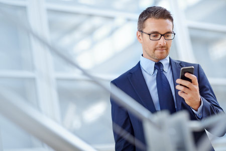 Networking, corporate or business man with phone for internet research, social media at hotel lobby before trip to an airport. Tech, online or ceo in on smartphone for travel blog review or appの写真素材