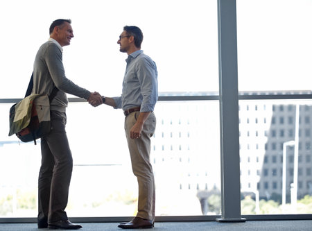 Mature business people, handshake or partnership deal in airport lounge, hotel lobby or modern office for financial crm. Smile, happy or corporate men shaking hands in welcome, thank you or greetingの写真素材