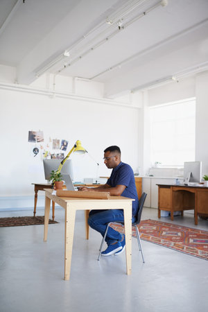 Creative, office or black man typing on laptop working on a blog project, digital or online...