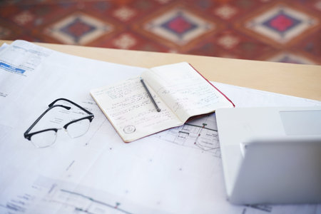 Notebook, laptop and blueprint on desk for architecture planning, strategy or layout at the office....