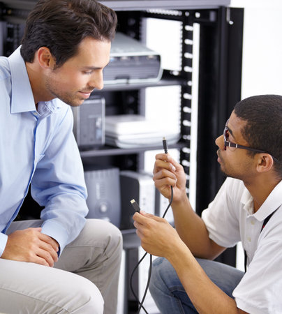Server room, it support and cables with a technician explaining to a business man about cyber...