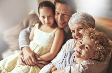 Smile, relax or happy grandparents with a children hug to embrace love together in family home in retirement. Elderly grandma, old man or kids relaxing, bonding or enjoying quality time togetherの写真素材