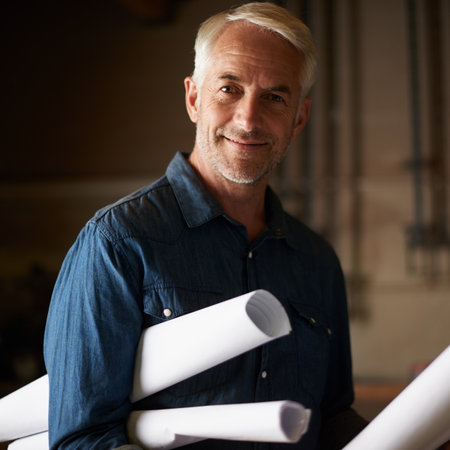 Senior architect, blueprint and man with smile in portrait, renovation or remodeling project with floor plan. Architecture industry, engineer and male professional designer with vision and missionの写真素材