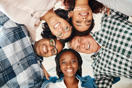 Stick together, succeed together. Low angle portrait of a team of creatives huddled together in unity.の写真素材