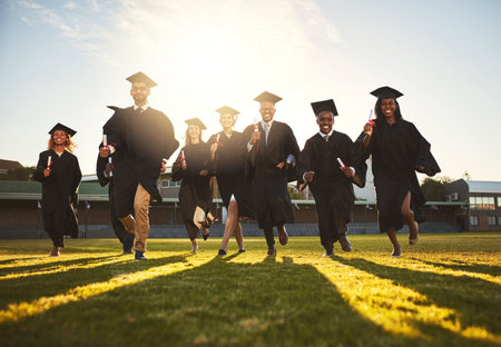 The future belongs to us. a group of university students running after being graduated.の写真素材