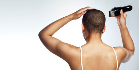 Let your story inspire others. Rearview shot of a young woman shaving her head against a white background.の写真素材