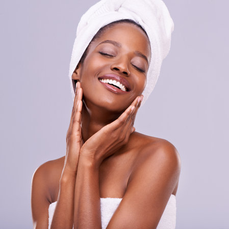 Beauty is self-confidence directly applied to the face. An isolated studio shot of a beautiful young woman wearing a towel on her head.の写真素材