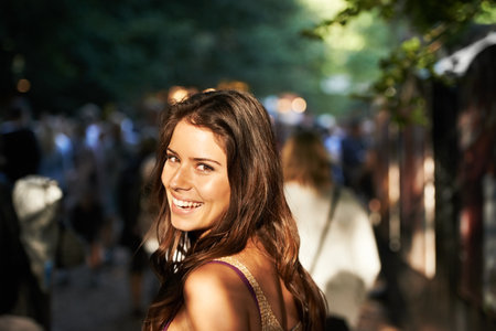 Awesome night ahead of us. A pretty young woman looking over her shoulder at you while walking towards the stage.の写真素材