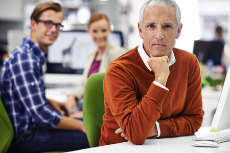 Bringing experience to the team. Portrait of coworkers sitting at computers in an office.の写真素材