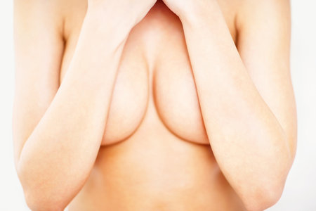Cover, closeup and breast of woman in studio for sensual, cleavage and temptation. Nude, topless and chest with body of girl for attractive, flirting and desire isolated on white backgroundの写真素材