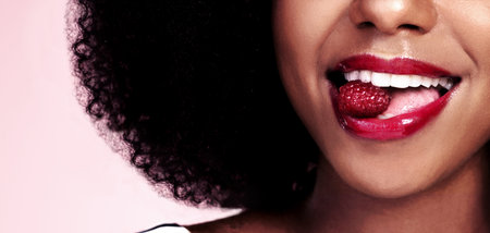 Bursting with flavor. an unrecognizable woman posing with a cherry in her mouth.