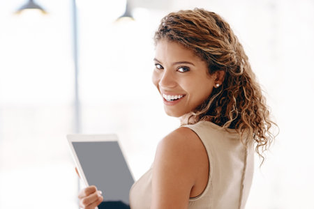 Bad business techniques are a thing of the past. Cropped portrait of an attractive young businesswoman using her laptop while standing in the office.の写真素材