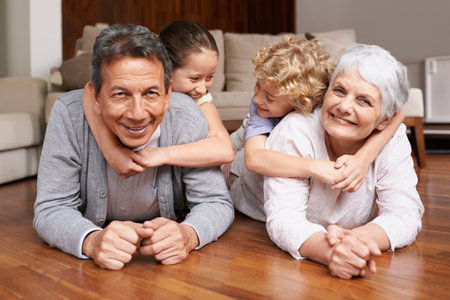 Well cherish these moments forever. Group shot of a brother and sister bonding with their grandparents.の写真素材