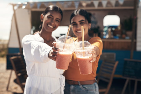 Spend time with those you love. two friends enjoying smoothies together.の写真素材