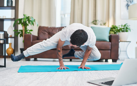 We get better through practice. a man using his laptop while practising yoga at home.