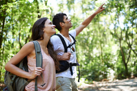They share a love for nature. a young couple hiking through the forest.の写真素材