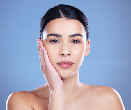 Your skin deserves a little love. an attractive young woman posing alone against a blue background in the studio.の写真素材