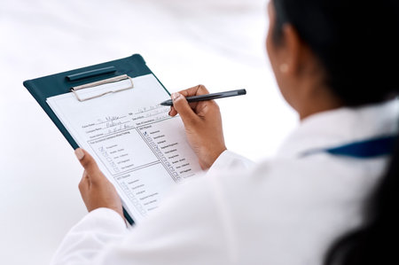 Checklist, woman doctor with clipboard and pen at the hospital. Check mark or tick for correct, document or scan results of person and medical female writing notes or prescription on page or sheetの写真素材