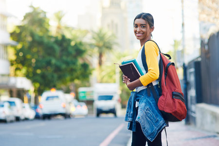 City walk, books and portrait woman, happy student or person on commute journey to university, college or high school. Outdoor street, education and girl smile for learning, studying or scholarshipの写真素材