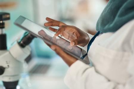 Optimising lab work with smart tech. Closeup shot of an unrecognisable scientist using a digital tablet in a lab.の写真素材