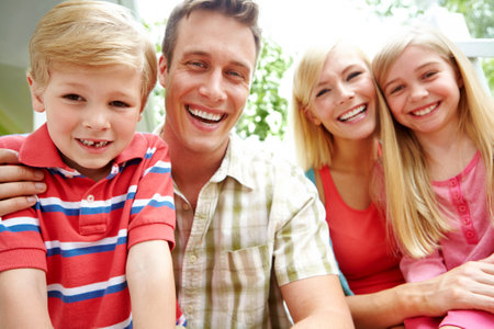 What an affectionate family. A family of four sitting together and smiling.の写真素材