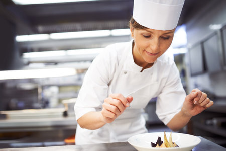 Gastronomy is an art. a chef preparing dessert in a professional kitchen.の写真素材
