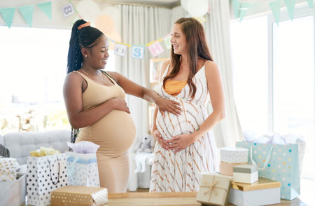 Can you feel him move. a woman feeling her friends baby move in her belly.の写真素材
