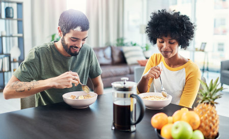 A good mood is only a good breakfast away. a young couple having breakfast together at home.の写真素材