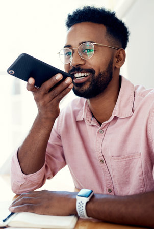 The fastest way to reply is via voice notes. a handsome young businessman sitting alone in the...