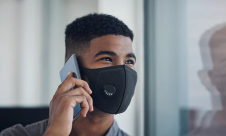 The pandemic wont stop him from advancing in his career. a young businessman wearing a face mask...