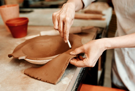 Lets get rid of the excess clay. an unrecognizable artisan working in a pottery workshop.