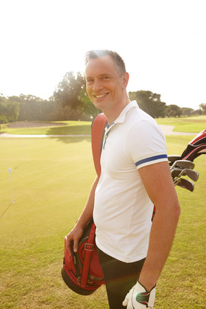 The best way to spend a day. Portrait of a happy man out for a day of golf.の写真素材