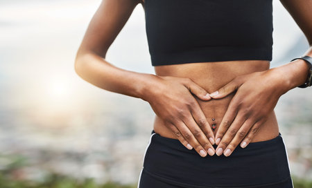 Love the shape youre in. Closeup shot of a sporty unrecognizable woman making a heart shape with her hands on her stomach outside.の写真素材