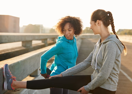 Ready to run. two friends stretching together before a run through the city streets.の写真素材