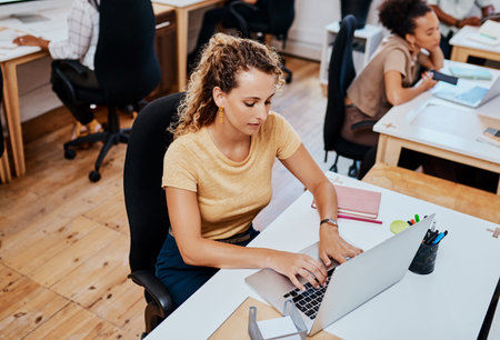 To get to the top youve got to stay focused. a young businesswoman using a computer in a modern...